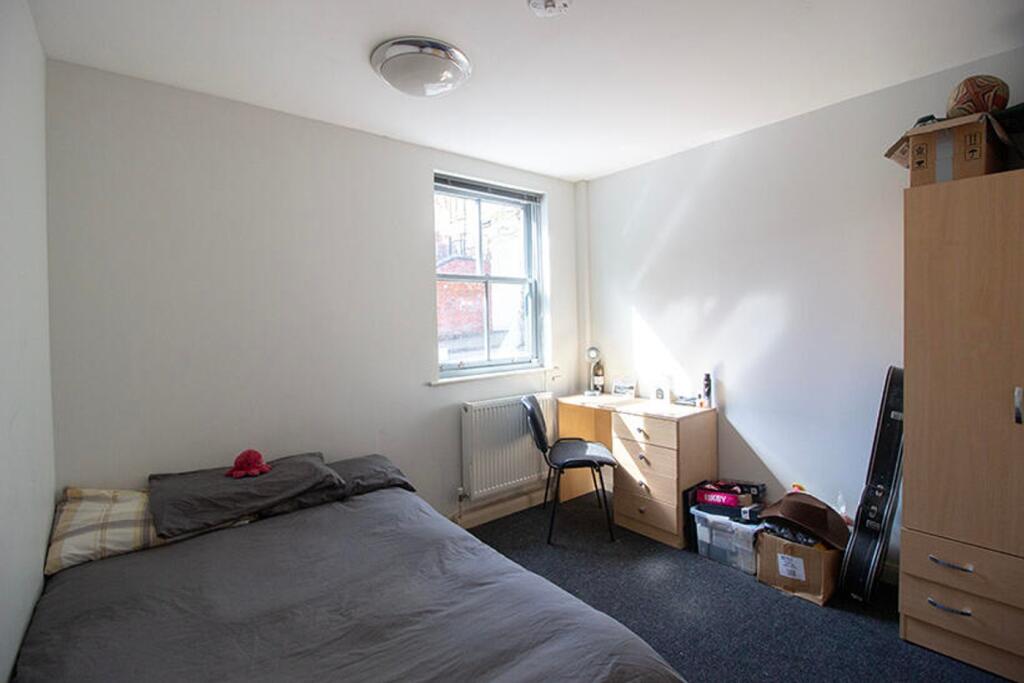 This inviting double bedroom features a cozy la...