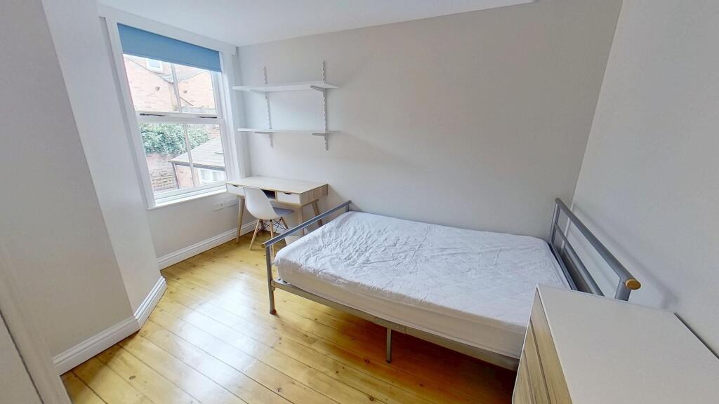 Bright and clean student bedroom featuring a si...