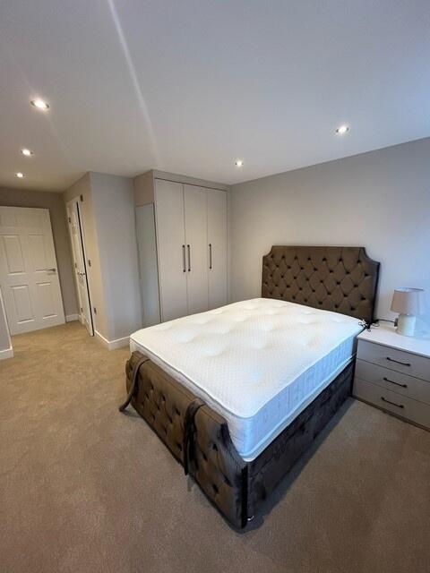 A modern double bedroom featuring a large comfo...