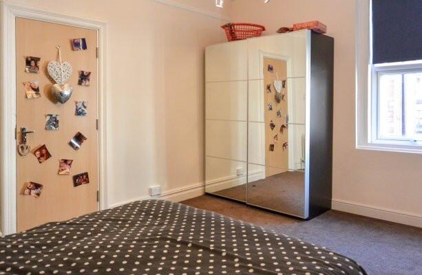 A cozy bedroom featuring a double bed with a po...