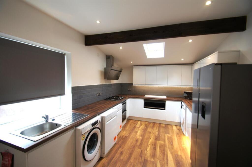 Modern kitchen featuring sleek cabinetry, ample...