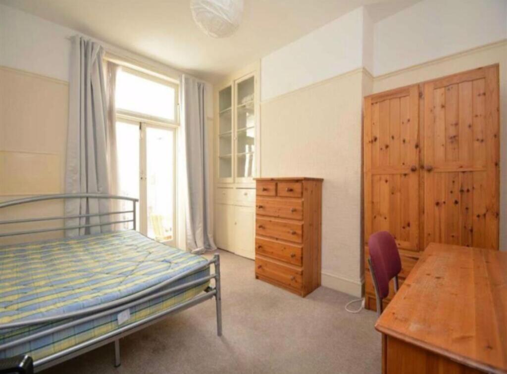 A spacious and well-lit double bedroom featurin...