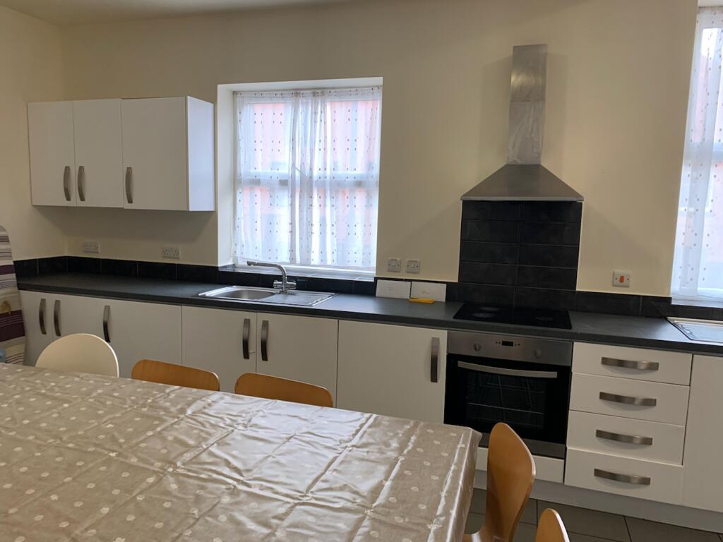 A spacious and bright kitchen with modern appli...