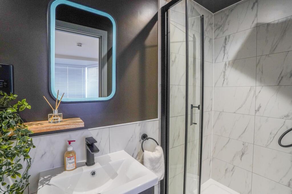 Modern bathroom featuring a stylish mirror with...