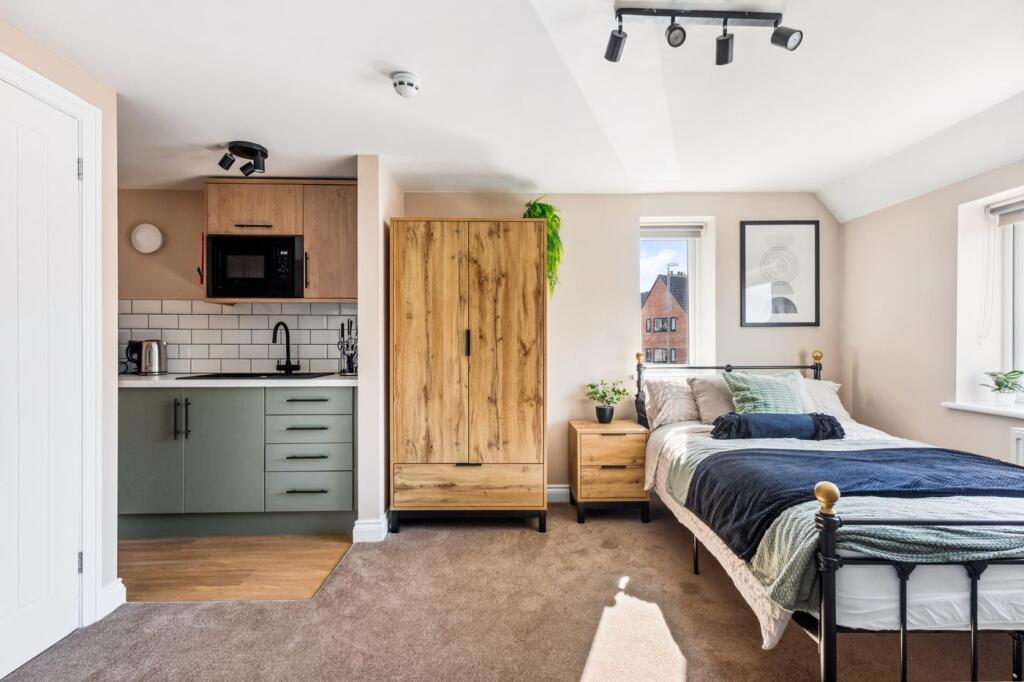 This stylish double bedroom features a cozy lay...