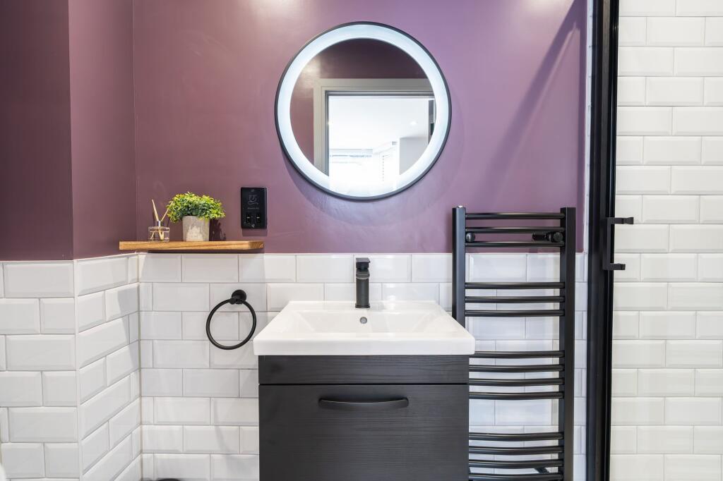 Modern bathroom featuring a stylish round illum...