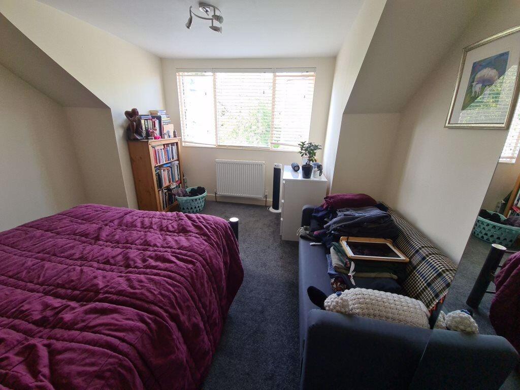 A bright and welcoming master bedroom featuring...