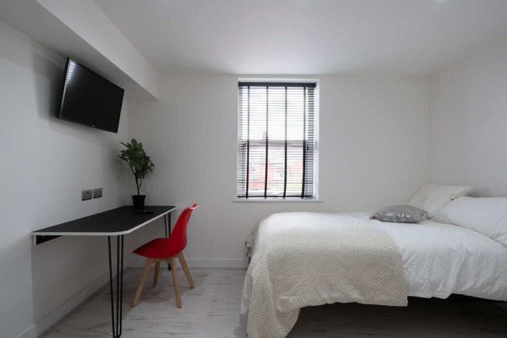 This stylish double bedroom features a comforta...
