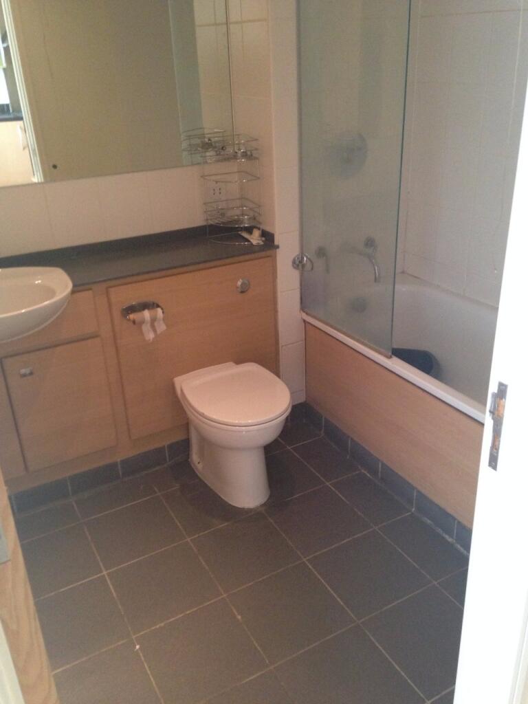 A clean and modern bathroom featuring a bathtub...
