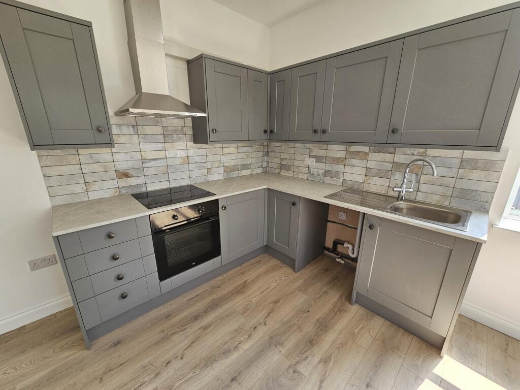 Modern fitted kitchen with grey shaker-style ca...