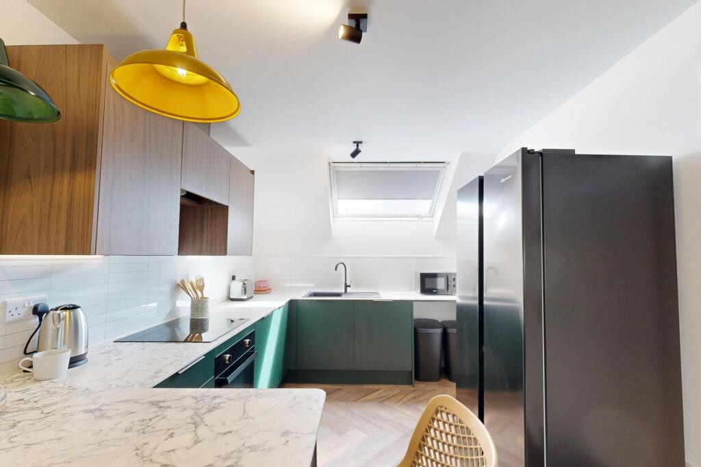 Bright modern kitchen with marble-effect workto...