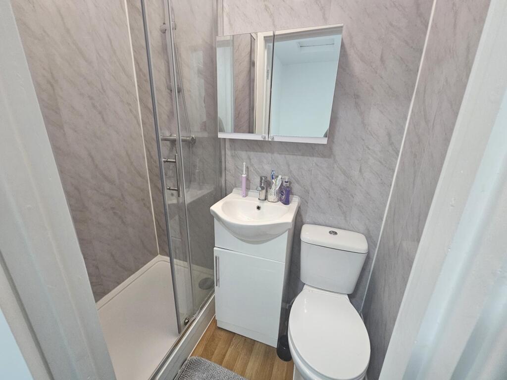 A modern bathroom with a compact shower unit, a...