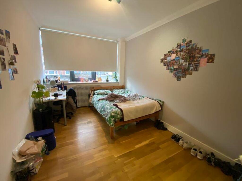 A bright and inviting double bedroom with a coz...