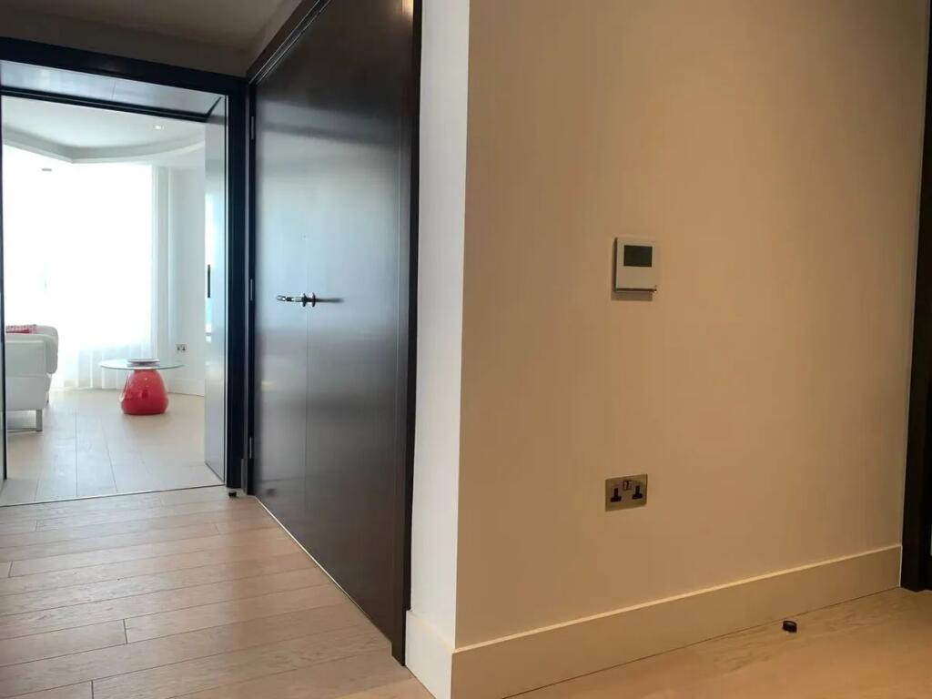 A modern hallway with light wooden flooring and...