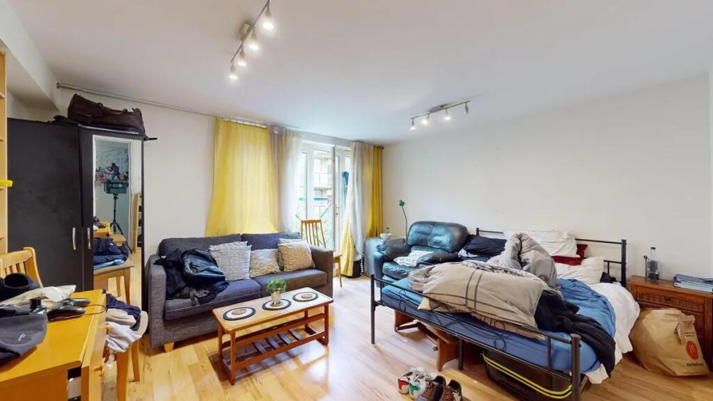 A spacious double bedroom featuring a cozy seat...