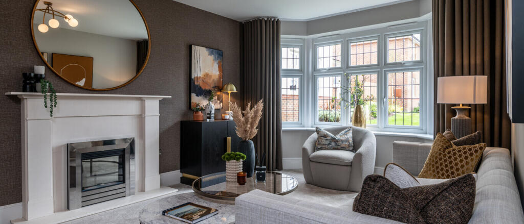 Contemporary living room with a white fireplace, large bay window, beige sofa, armchair, and elegant