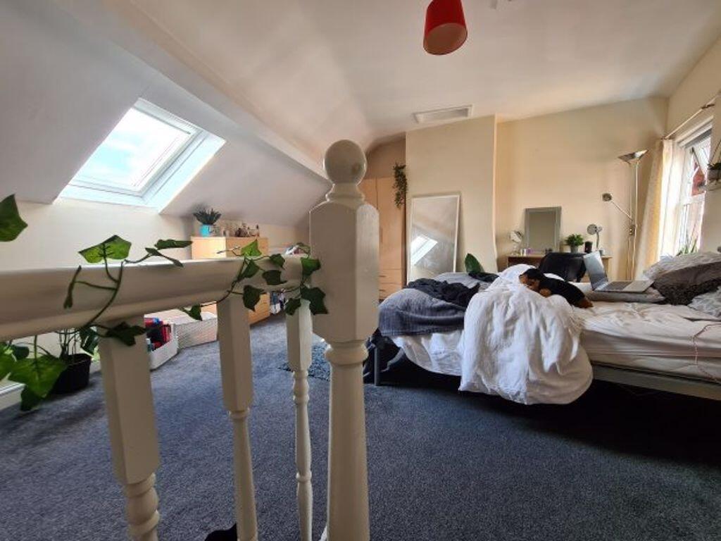 A cozy bedroom with sloped ceiling featuring a ...