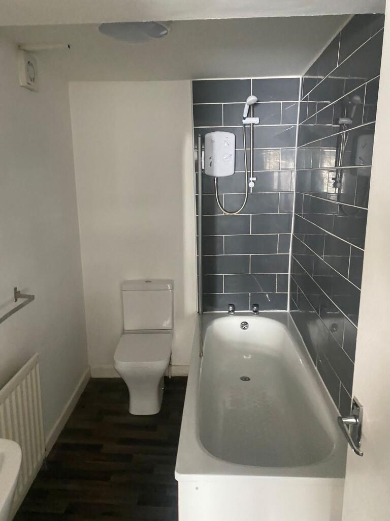 Clean and functional bathroom featuring a batht...