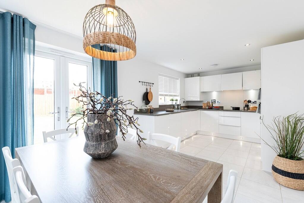 The open-plan kitchen/dining area features double doors out to the garden