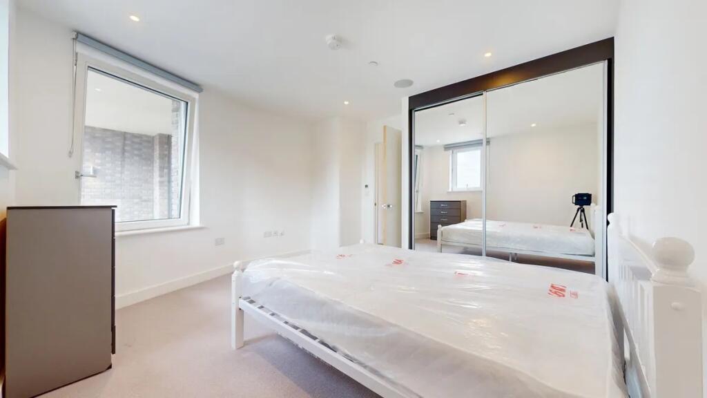 A bright and clean double bedroom featuring a l...