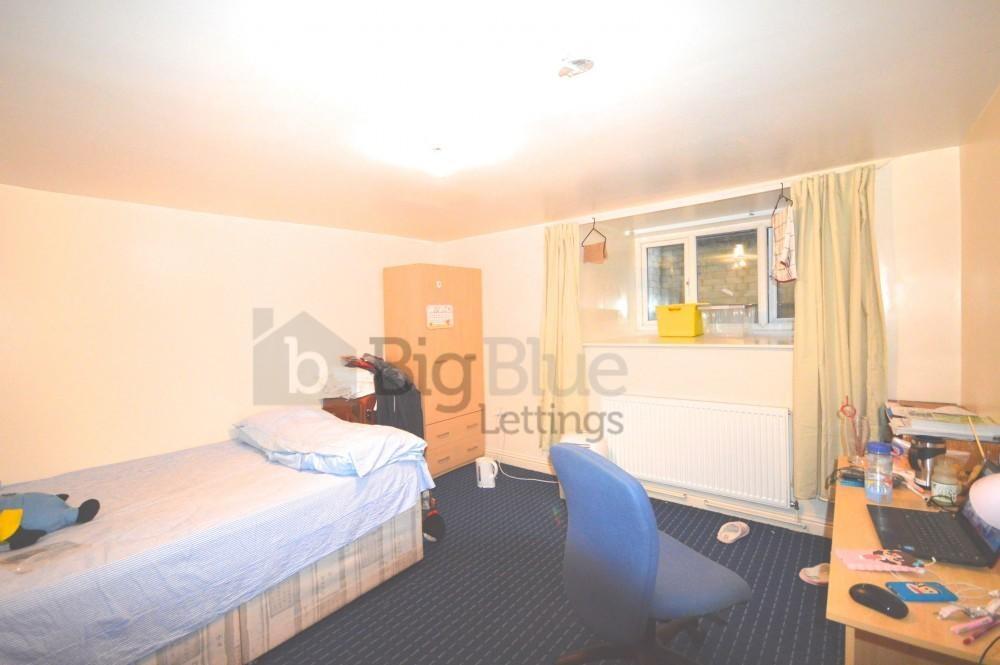 A cozy single bedroom with a neatly made single...