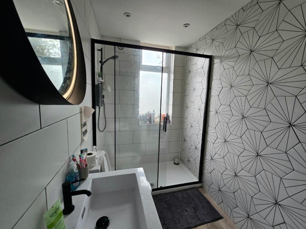 A modern bathroom featuring a walk-in shower wi...