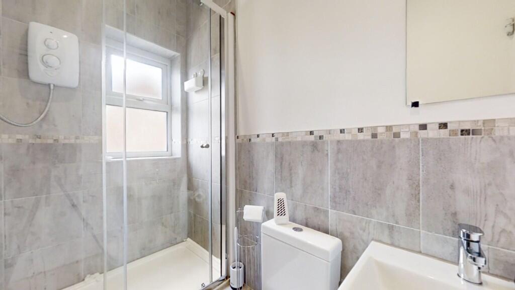A modern bathroom featuring a walk-in glass sho...