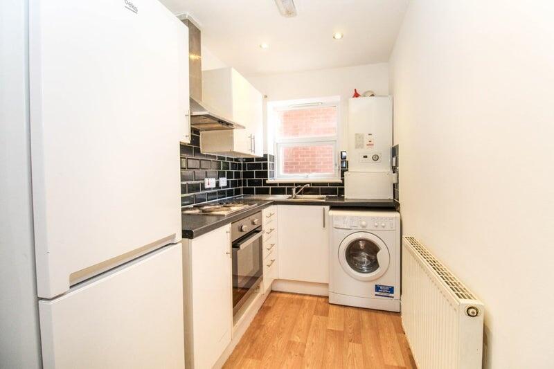 Bright and modern kitchen featuring white cabin...