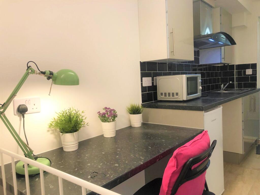 A compact and tidy kitchen area featuring a sle...
