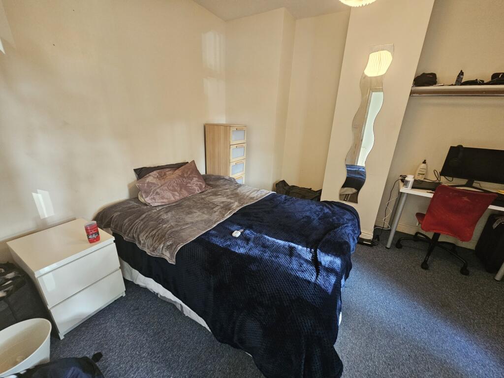 A cozy single bedroom featuring a neatly made b...