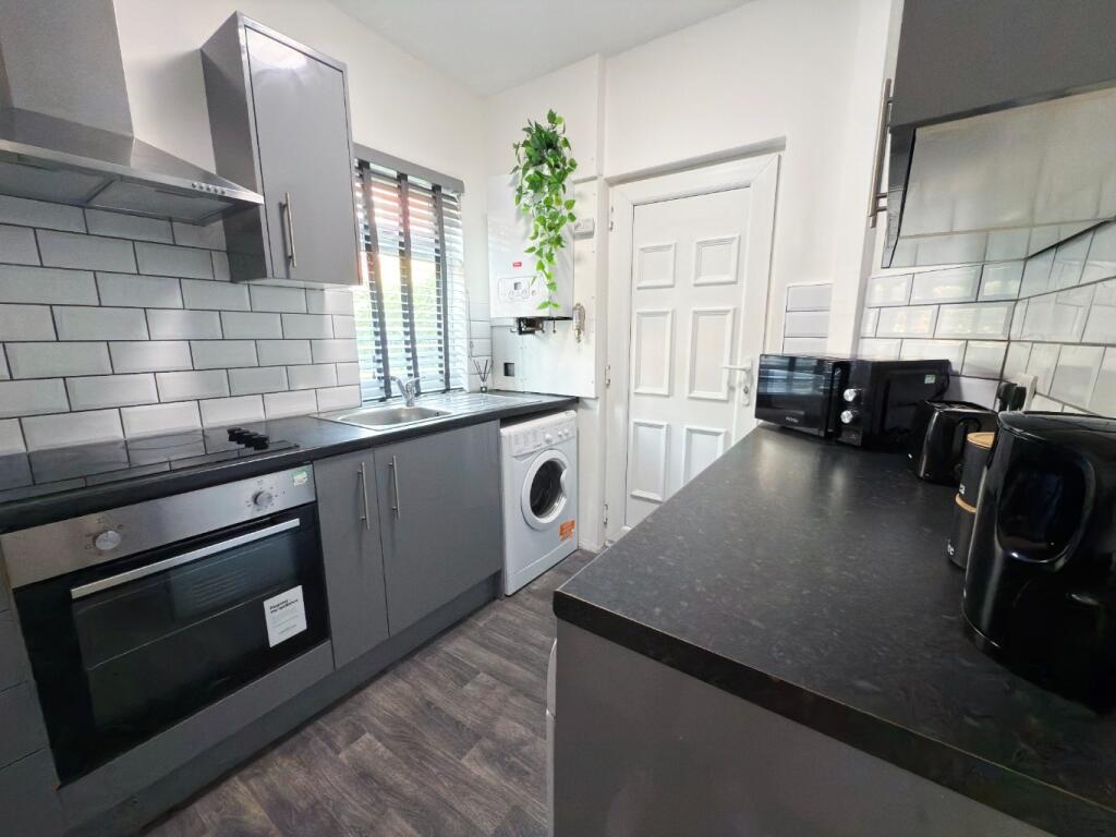 Modern galley kitchen with sleek grey cabinets,...