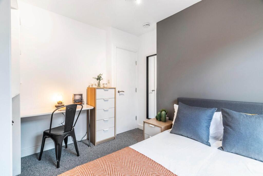 A cozy and well-maintained bedroom featuring a ...