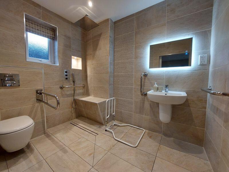 A spacious, modern bathroom suite featuring a l...