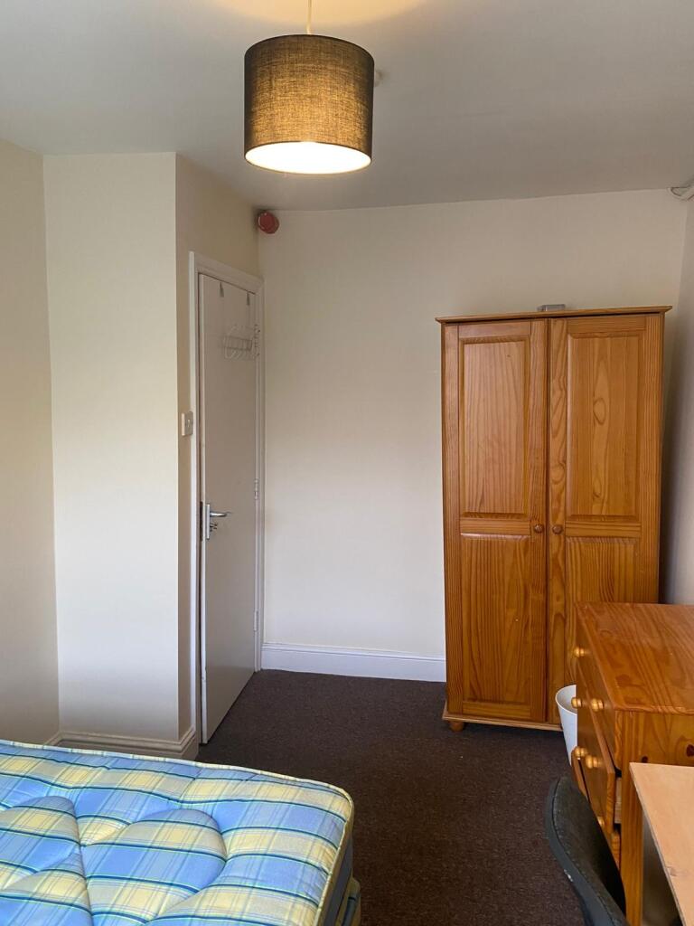 A tidy bedroom featuring a comfortable single b...