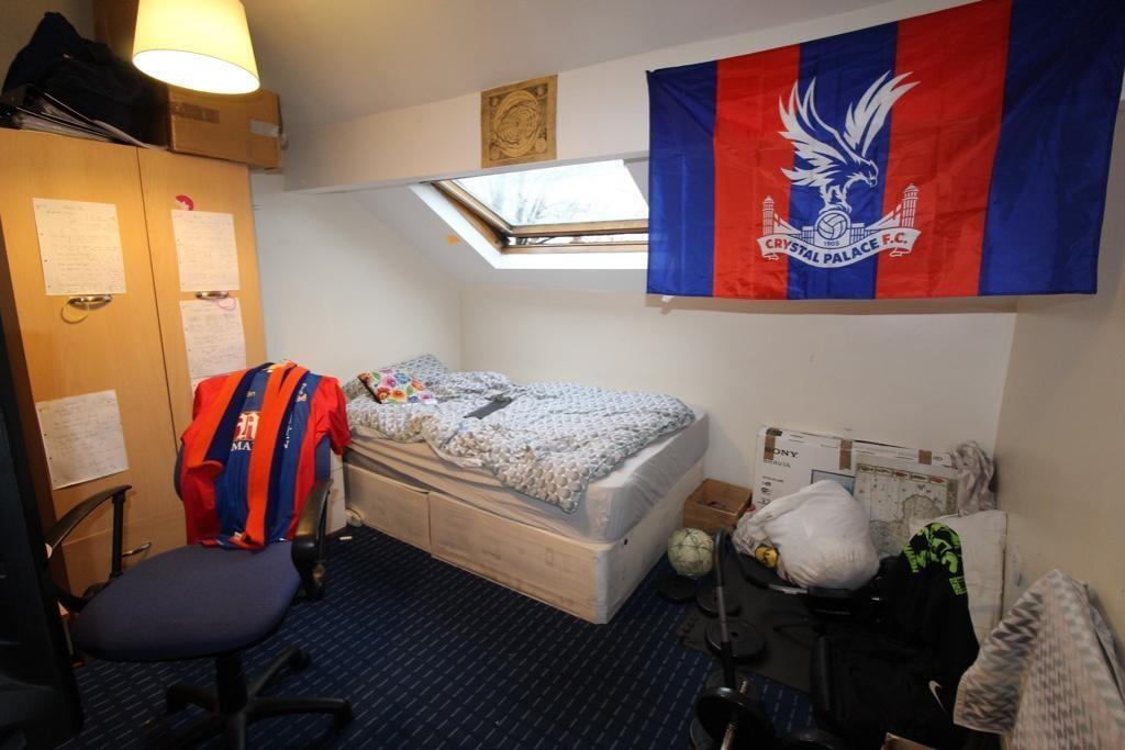 Cozy attic-style bedroom with a single bed bene...