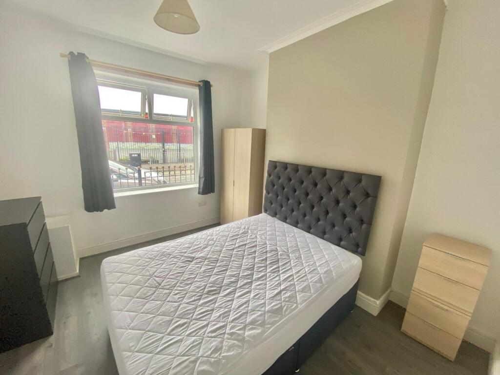 Bright double bedroom with a large window provi...