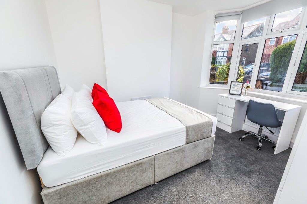 This stylish double bedroom features a comforta...