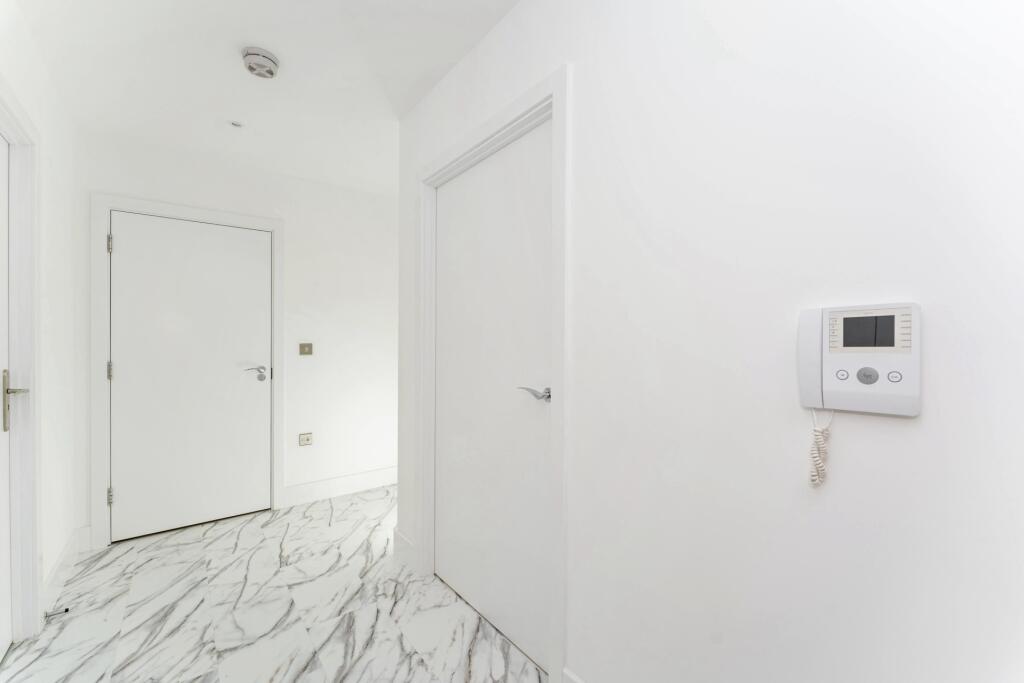 Bright and clean hallway featuring modern white...