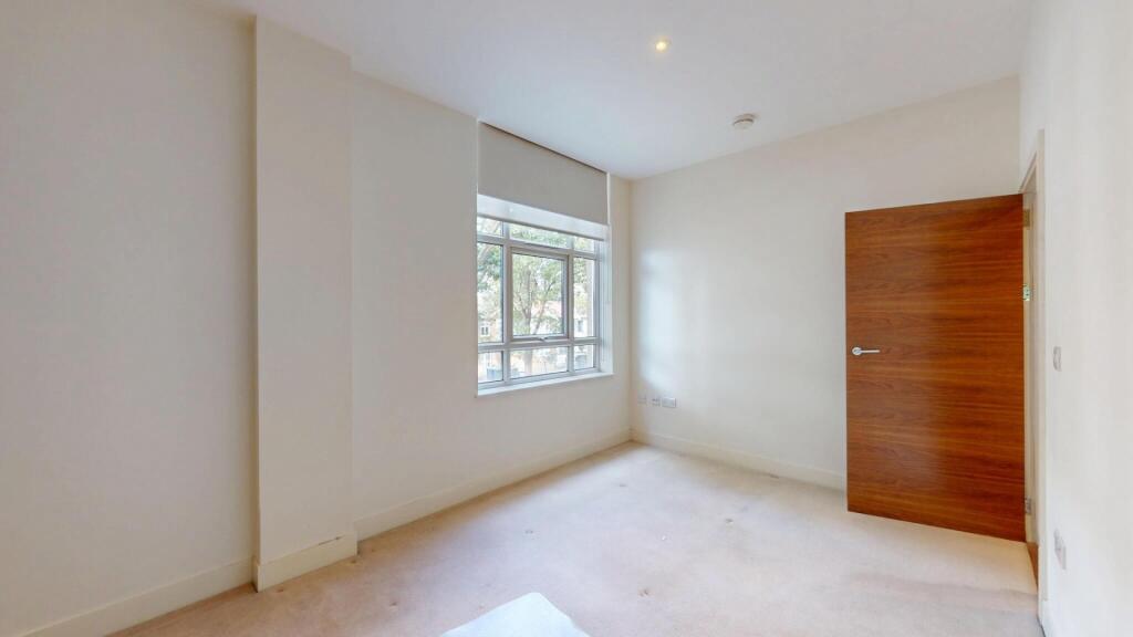 A bright and clean single bedroom featuring a l...