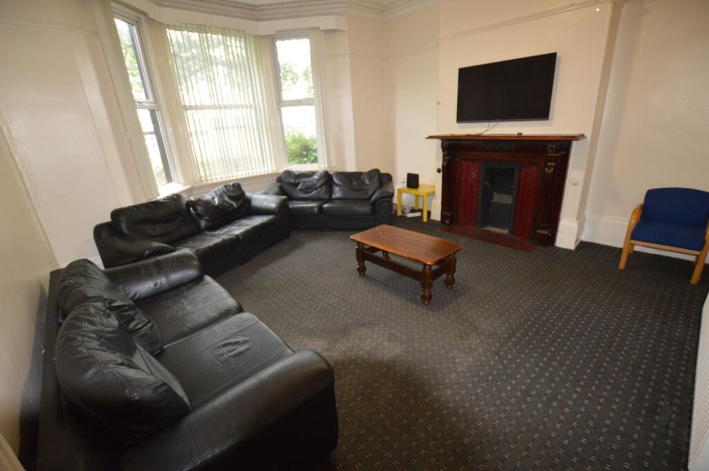 Spacious living room featuring three large blac...
