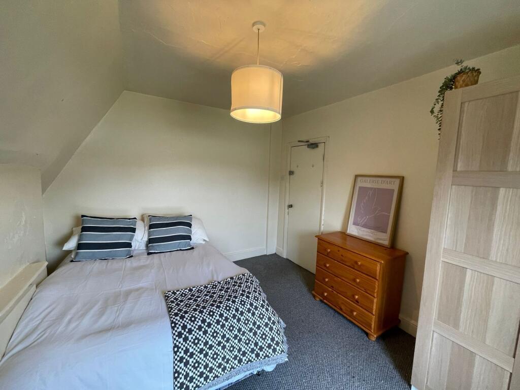 A cozy and well-maintained bedroom featuring a ...