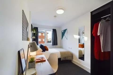A bright and neatly arranged single bedroom fea...
