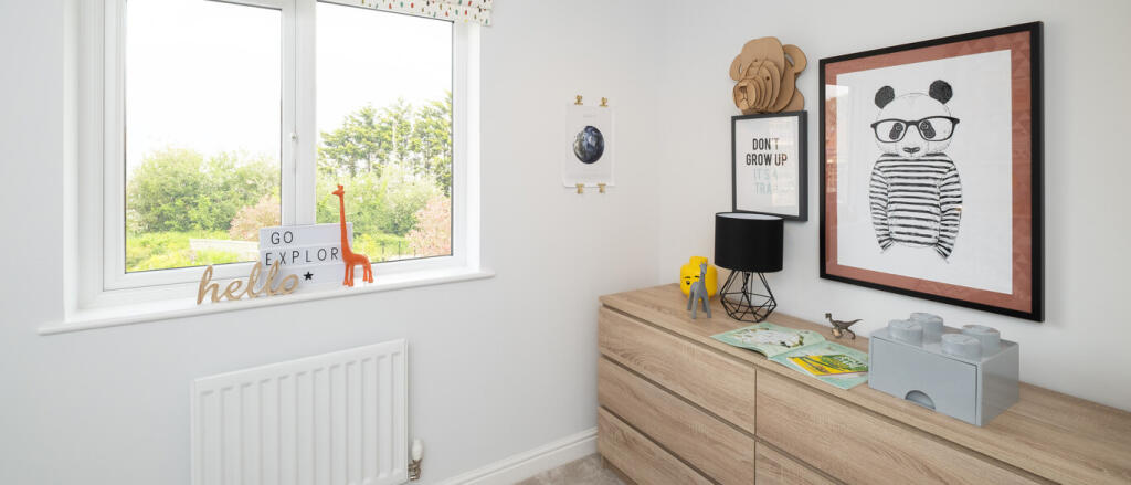 A bright children's bedroom with a wooden dresser, panda artwork, toys, books, and a window showing