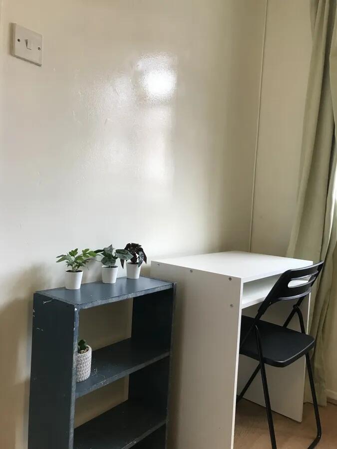 A bright, tidy study area with a white desk and...