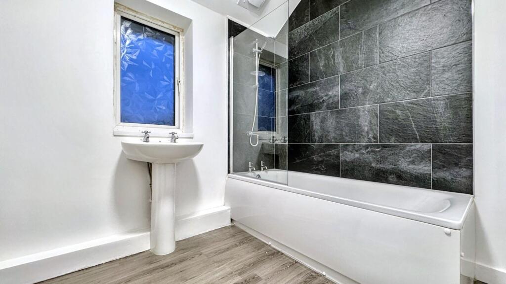 A spacious and modern bathroom featuring a rela...