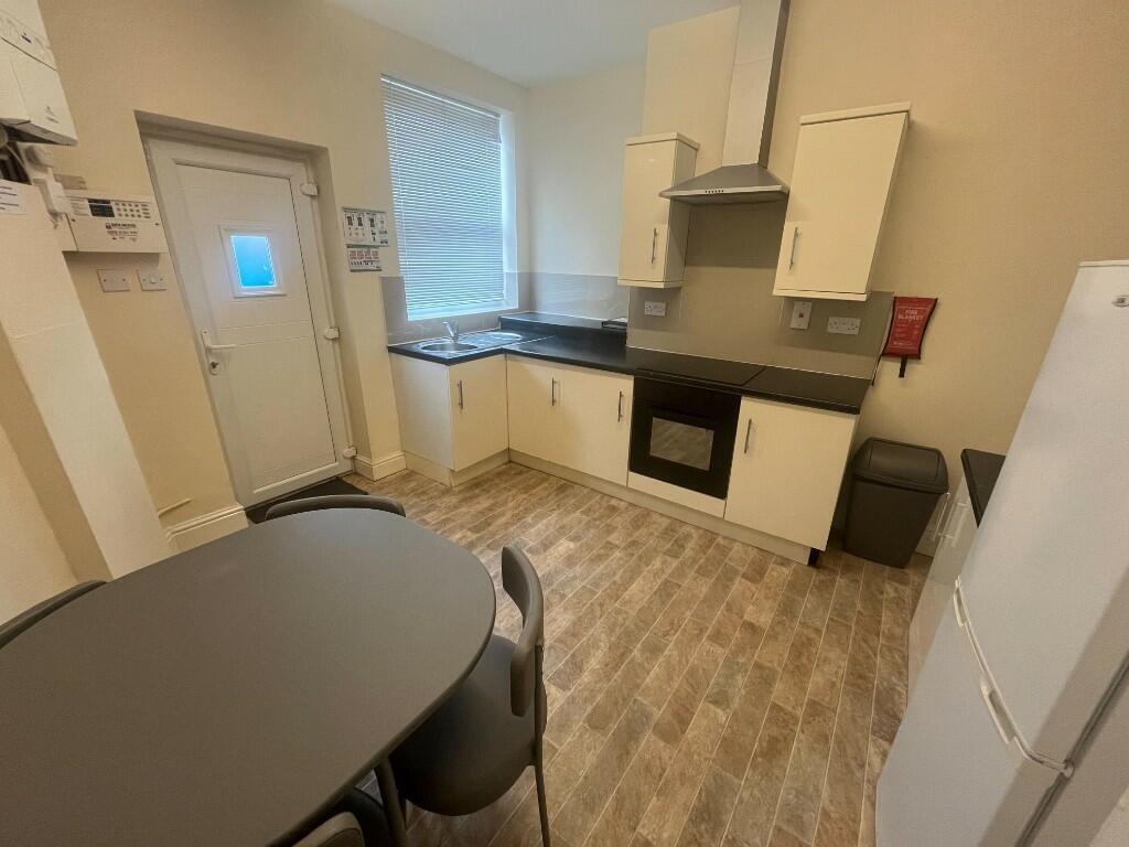 Bright and tidy kitchen featuring modern cabine...
