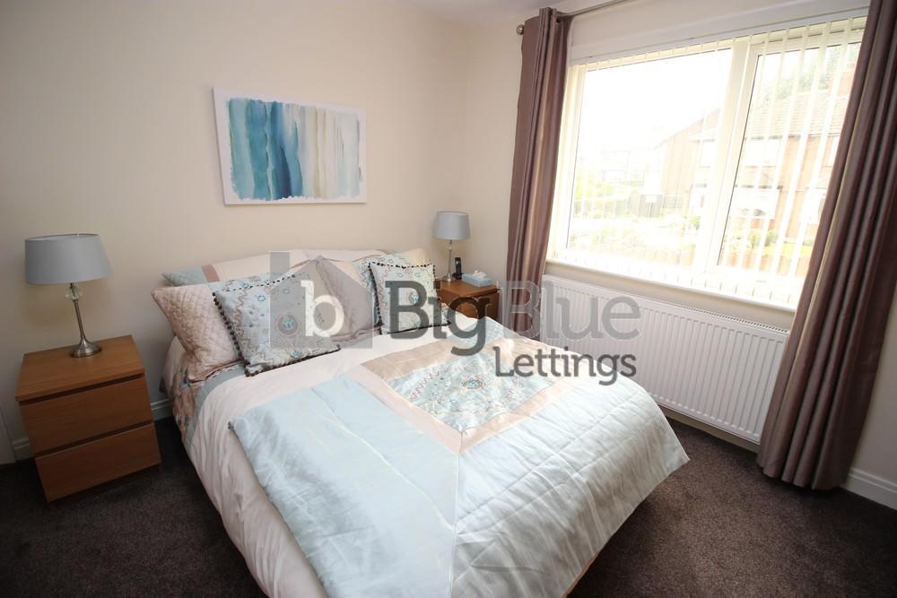 A cozy double bedroom featuring a neatly made b...