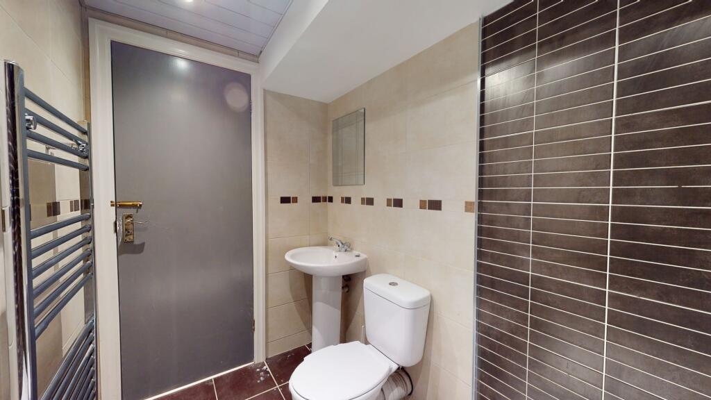 A modern, compact bathroom featuring a white to...