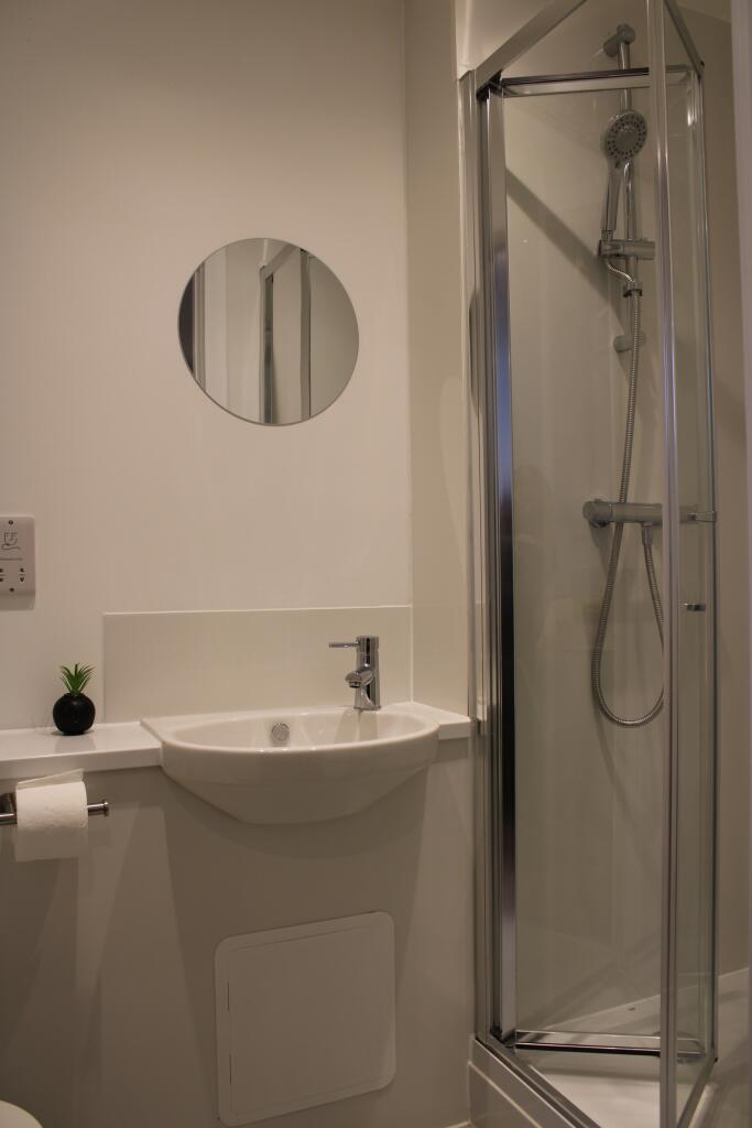 A modern and tidy bathroom featuring a sleek sh...