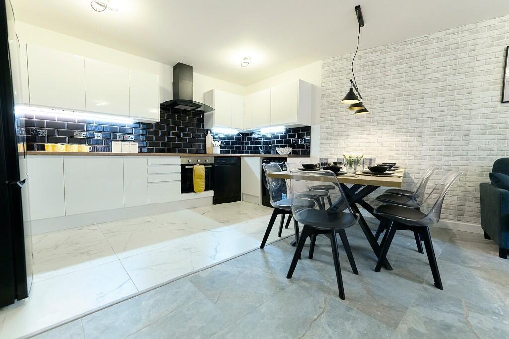 A modern, sleek kitchen and dining area featuri...